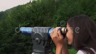 女孩用旅游望远镜看山和树林